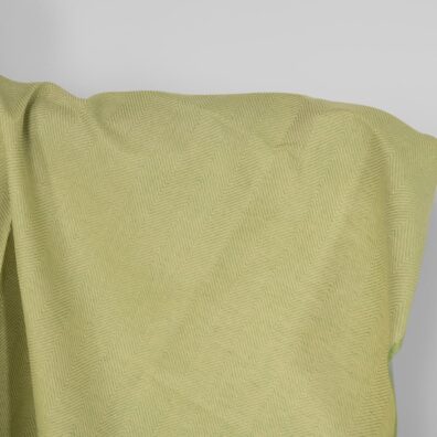 Puslininis audinys gelsvai žaliu „eglutės“ raštu